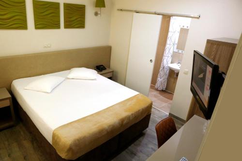 a small bedroom with a bed and a television at Hotel de France in Brussels