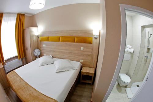 a bedroom with a bed and a shower and a toilet at Hotel de France in Brussels