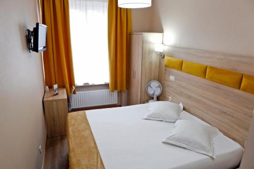 a bedroom with a white bed and a window at Hotel de France in Brussels