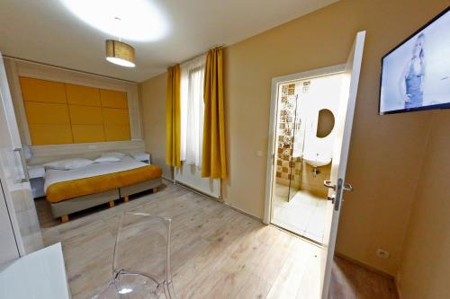 a bedroom with a bed and a television and a bathroom at Hotel de France in Brussels