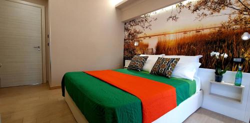a bedroom with a colorful bed with a painting on the wall at Grillo Superior Apartments in Capo Vaticano
