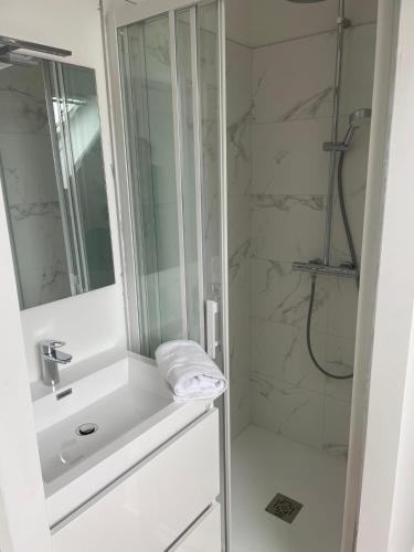 une salle de bain blanche avec un lavabo et une douche dans l'établissement Le Poulorio 13 - T2 - Proche Gare, à Lorient