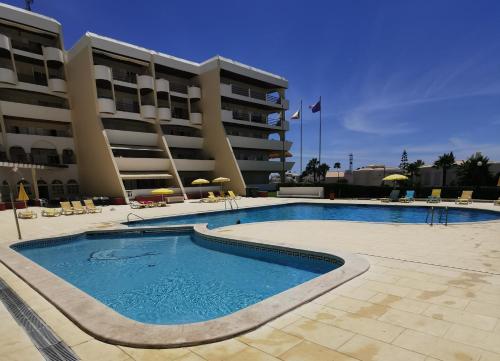 uma grande piscina em frente a um edifício em Apartamento T2 Palmeira Galé-Praia da Galé na Guia