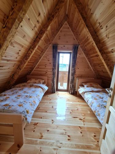 une chambre avec deux lits dans une cabane en rondins dans l'établissement Original Wooden Lodge 2, à Žabljak
