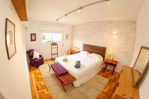 1 dormitorio con cama y pared de ladrillo en Ótima localização! Longa Estadia em Pinheiros., en São Paulo