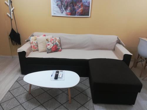 una sala de estar con un sofá y una mesa en Central Apartment, en Tesalónica