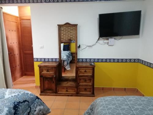 Una televisión o centro de entretenimiento en Hotel Y Suites Axolotl