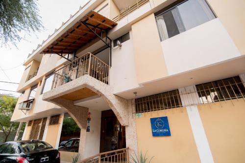 ein Gebäude mit Balkon und einem davor geparkten Auto in der Unterkunft Hotel La Coruña in Piura