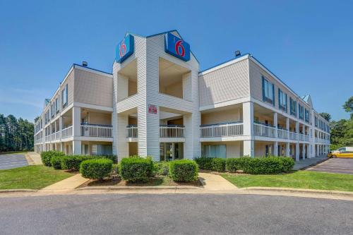a large apartment building with a sign on it at Motel 6-Raleigh, NC - North in Raleigh