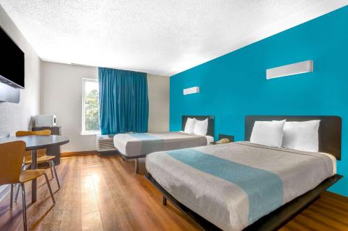 a hotel room with two beds and a table at Motel 6-Raleigh, NC - North in Raleigh