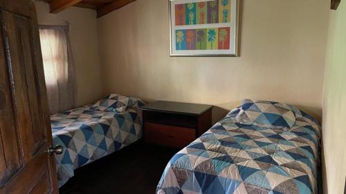 マサミトラにあるCabañas Yasminaのベッドルーム1室(ベッド2台、テーブル、写真付)