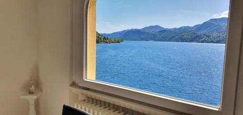 a window with a view of a body of water at Beautiful Place a Lago d'Orta mit direktem Seezugang in Omegna