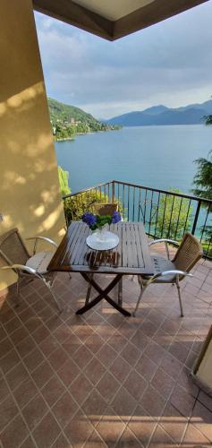 a table and chairs on a patio with a view of the water at Beautiful Place a Lago d'Orta mit direktem Seezugang in Omegna
