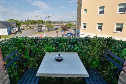 een tafel en stoelen op een balkon met een gebouw bij Le Vannier cute T2 of 26 m city center closed garage balcony in Honfleur