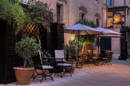 an outdoor patio with tables and chairs and an umbrella at Grand Hotel de l'Opera - BW Premier Collection in Toulouse