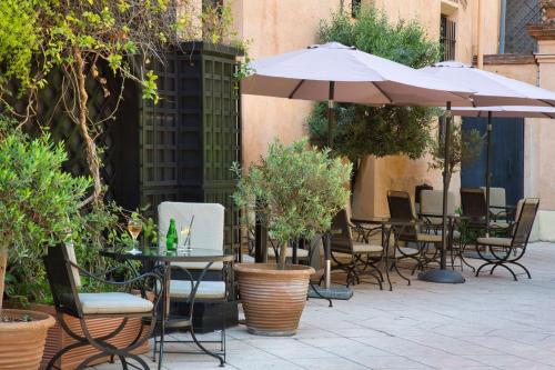an outdoor patio with chairs and tables with umbrellas at Grand Hotel de l'Opera - BW Premier Collection in Toulouse