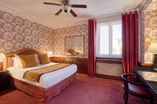 a bedroom with a bed and a desk and a window at Grand Hotel de l'Opera - BW Premier Collection in Toulouse