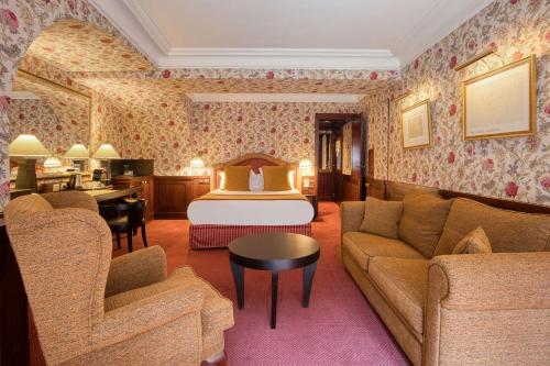 a hotel room with a bed and a living room at Grand Hotel de l'Opera - BW Premier Collection in Toulouse