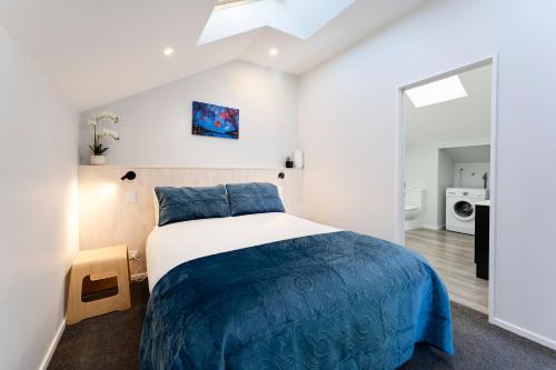 a bedroom with a large bed with a blue blanket at Shotover Country piece of paradise in Queenstown