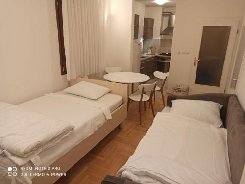 a room with two beds and a table and a kitchen at Zagreb LAKE STAR & Included garage parking place in Zagreb