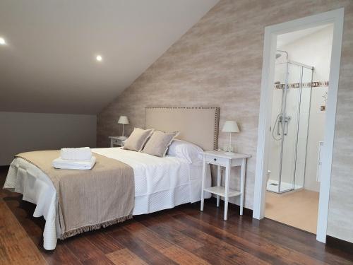 sypialnia z białym łóżkiem i lustrem w obiekcie Apartamento A casa da feira w mieście Pontevedra