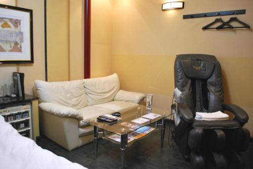 a living room with a couch and a chair at Ena Hotel Venus in Ena