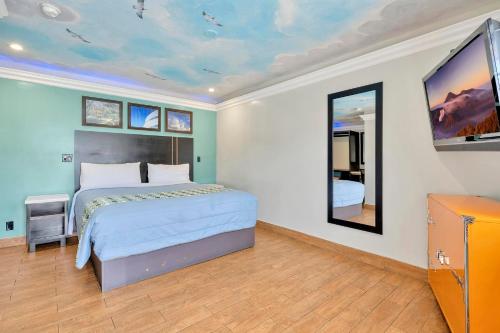 a bedroom with a large bed and two mirrors at Mid City Inn in Los Angeles