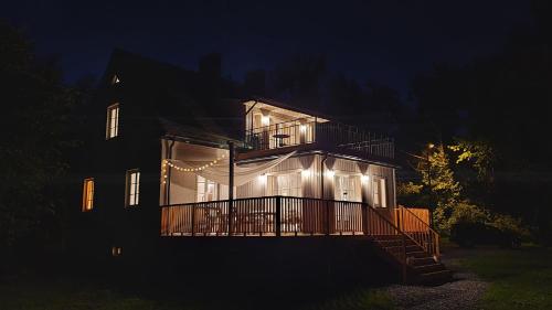 a large house with lights on it at night at Nasz Dębowiec - dom dla 15 osób, sauna, widok na staw, wielka działka in Dębowiec