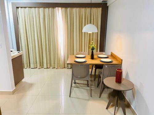 a dining room with a wooden table and chairs at Flat 303 - Condomínio Park Veredas - Acesso ao Rio - Completo com ar no quarto e na sala in Rio Quente
