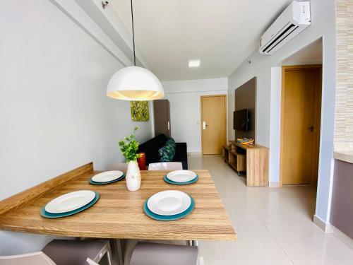 a dining room table with blue and white plates on it at Flat 303 - Condomínio Park Veredas - Acesso ao Rio - Completo com ar no quarto e na sala in Rio Quente