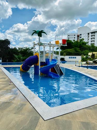 a large swimming pool with a slide in the water at Flat 303 - Condomínio Park Veredas - Acesso ao Rio - Completo com ar no quarto e na sala in Rio Quente