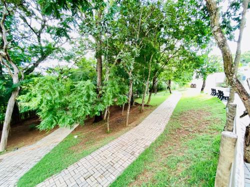a path in a park with trees and benches at Flat 303 - Condomínio Park Veredas - Acesso ao Rio - Completo com ar no quarto e na sala in Rio Quente