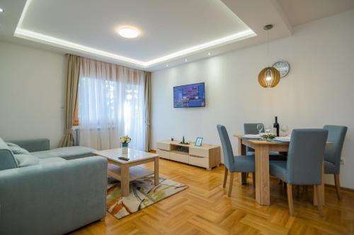 a living room with a couch and a table with chairs at Bora Bora Apartmani Zlatibor in Zlatibor