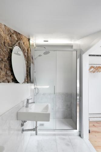 a white bathroom with a sink and a mirror at Room Lusíadas with private bathroom in Lisbon