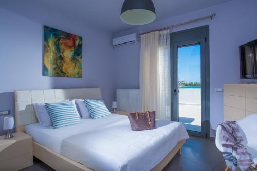 a blue bedroom with two beds and a window at Coast Suite-Luxury Central Beach House in Hersonissos