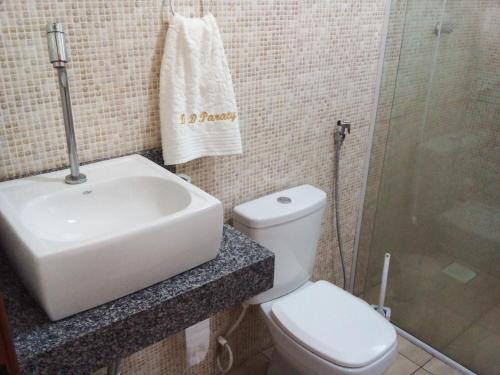 a bathroom with a toilet and a sink and a shower at Casa na praia do Jabaquara in Paraty
