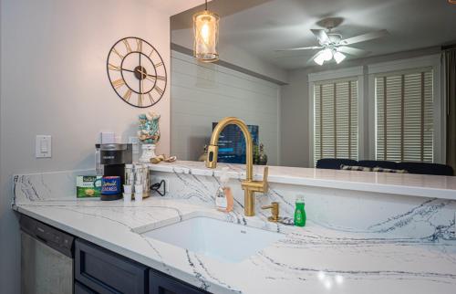 a kitchen with a sink and a clock on the wall at The Grand Sandestin in Destin