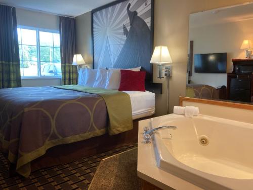 a hotel room with a bed and a bath tub at Super 8 by Wyndham Chisago City in Chisago City
