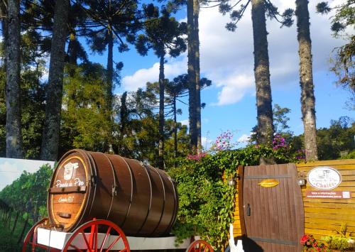 a wooden barrel sitting on a cart next to a wooden box at Chalé Temático em Pipa de Vinho - Parada da Pipa Chalés in Canela
