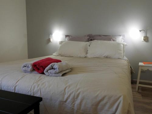 ein großes weißes Bett mit zwei Handtüchern darauf in der Unterkunft Gîte Dommartin-le-Franc, 3 pièces, 4 personnes - FR-1-611-64 