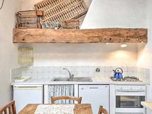 a kitchen with white cabinets and a sink and a table at Belvilla by Oyo San Godenzo Casa Grande 2 in San Godenzo