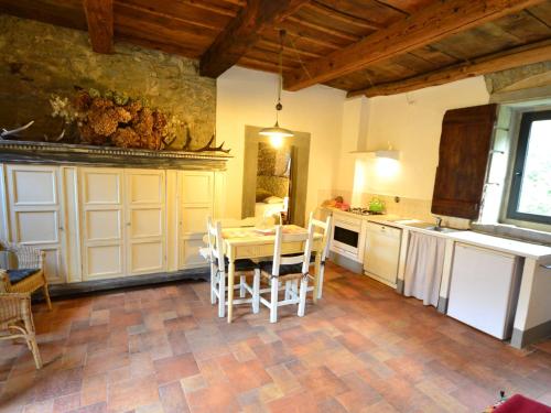 a kitchen with a table and chairs in a room at Belvilla by Oyo Rustic holiday home with pool in San Godenzo