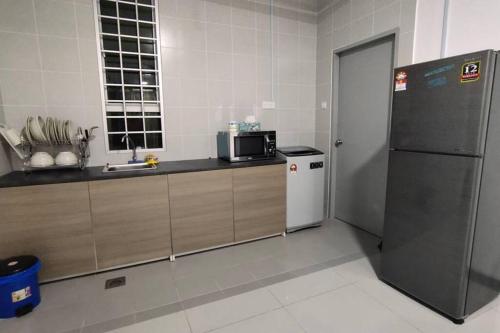 una cucina con frigorifero e forno a microonde di Pangsapuri Ladang Tanjung a Kuala Terengganu