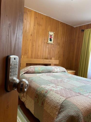 a bedroom with a bed with a remote control at Hostal el Nogal Pucón in Pucón
