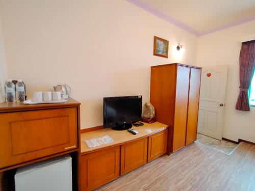 a room with a tv on a wooden stand with a desk at 陶陶居商旅 Tautauchu Hotel in Hualien City