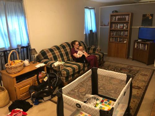 a woman sitting on a couch holding a baby at Copperville B & B in Glennallen