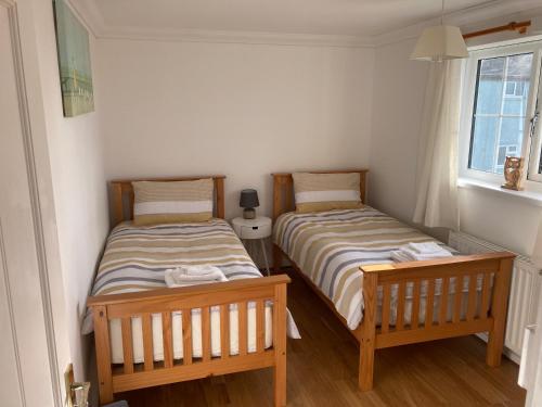 dos camas sentadas una al lado de la otra en una habitación en Bader House en Aberporth