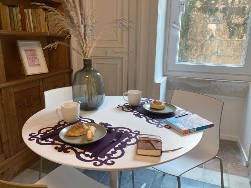 een tafel met twee kopjes en borden voedsel erop bij Sognalibro Bed and Books in Ragusa