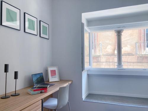 a room with a desk with a laptop and a window at Sognalibro Bed and Books in Ragusa