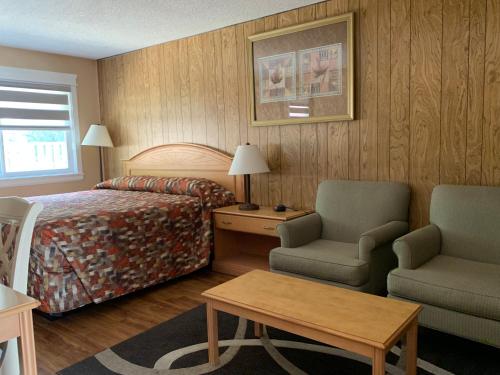 a hotel room with a bed and two chairs and a table at Green View Motel and RV Park in Greenwood